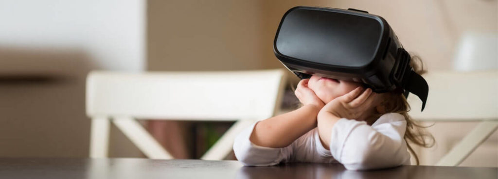 A child wearing a virtual reality headset on a table