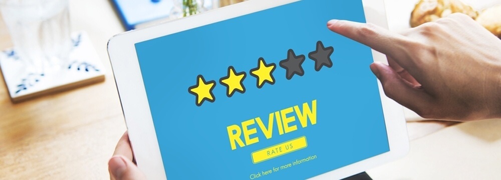 A person holding a tablet with the word review on it
