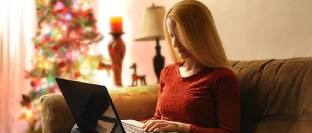 A woman sitting on a couch with a laptop